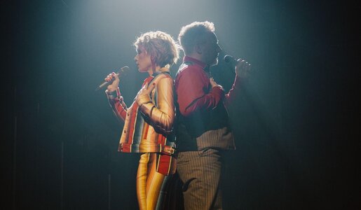 Bühnenaufnahme: Eine Frau mit kurzen Haaren und ein grauhaariger Mann singen konzentriert Rücken an Rücken im Spotlight. | © RTL / Anna Riedel