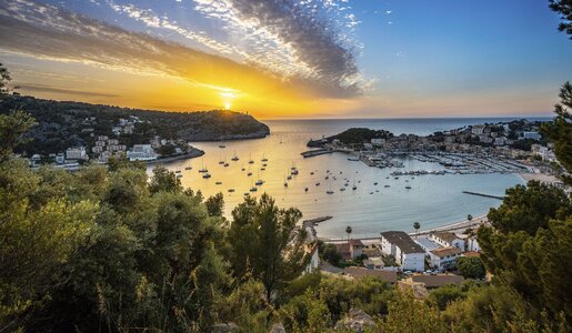 Blick auf eine idyllische Hafenbucht mit vielen Segelbooten im goldenen Licht eines dramatischen Sonnenuntergangs über dem Meer. | © HR / Joel Hess