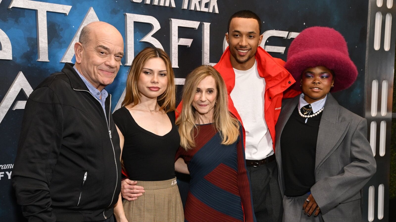 Der Cast von Starfleet Academy schaut bei einem Pressetermin vor einem Werbeplakat in die Kamera. | © Getty Images/Michael Tullberg / Kontributor