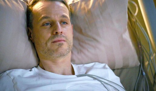 Ein junger Mann mit blauen Augen liegt ernst und reglos auf einem Kissen, neben ihm hängen Kabel an einem Krankenbett. | © RTL