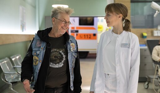 Lisa Schroth (Louise Sophie Arnold) nimmt in der Notaufnahme der Sachsenklinik Peter "Bumble" Hummel (Martin Semmelrogge) auf. Ein Rock 'n' Roller aus Leib und Seele, der Lisa sofort seine ganzen Tourneegeschichten als Roadie mit den größten Stars der Welt erzählt. | © MDR/Rudolf Wernick