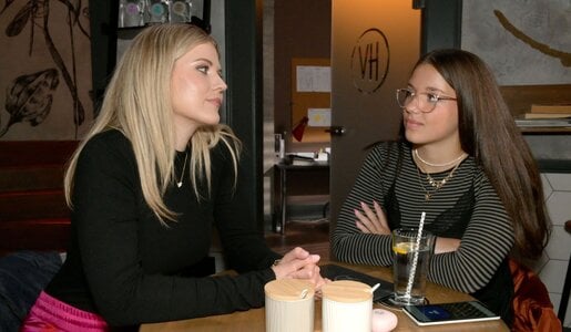 Alicia und Kate blicken sich an und sitzen bei Wasser und Smartphone in gemütlicher Café-Atmosphäre. | © RTL / Rolf Baumgartner