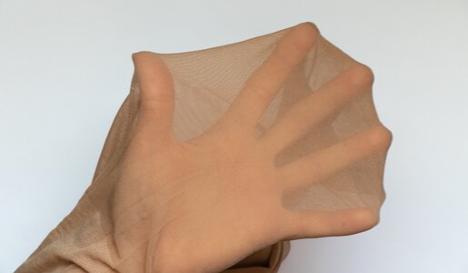 Hand in Nylonstumpfhose vor weißen Hintergrund | ©  Getty Images/ Victoria Kotlyarchuk